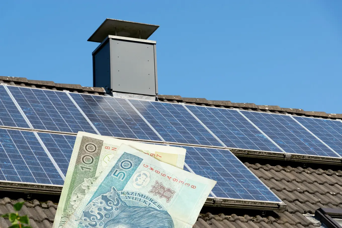 polskie banknoty na tle paneli solarnych